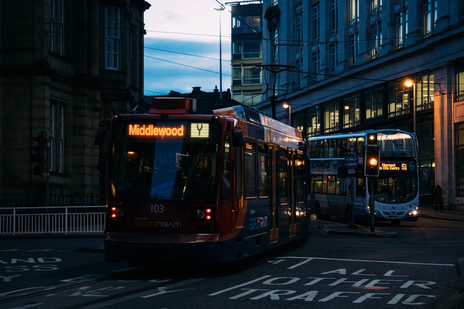 A bus and a tram in a city centre